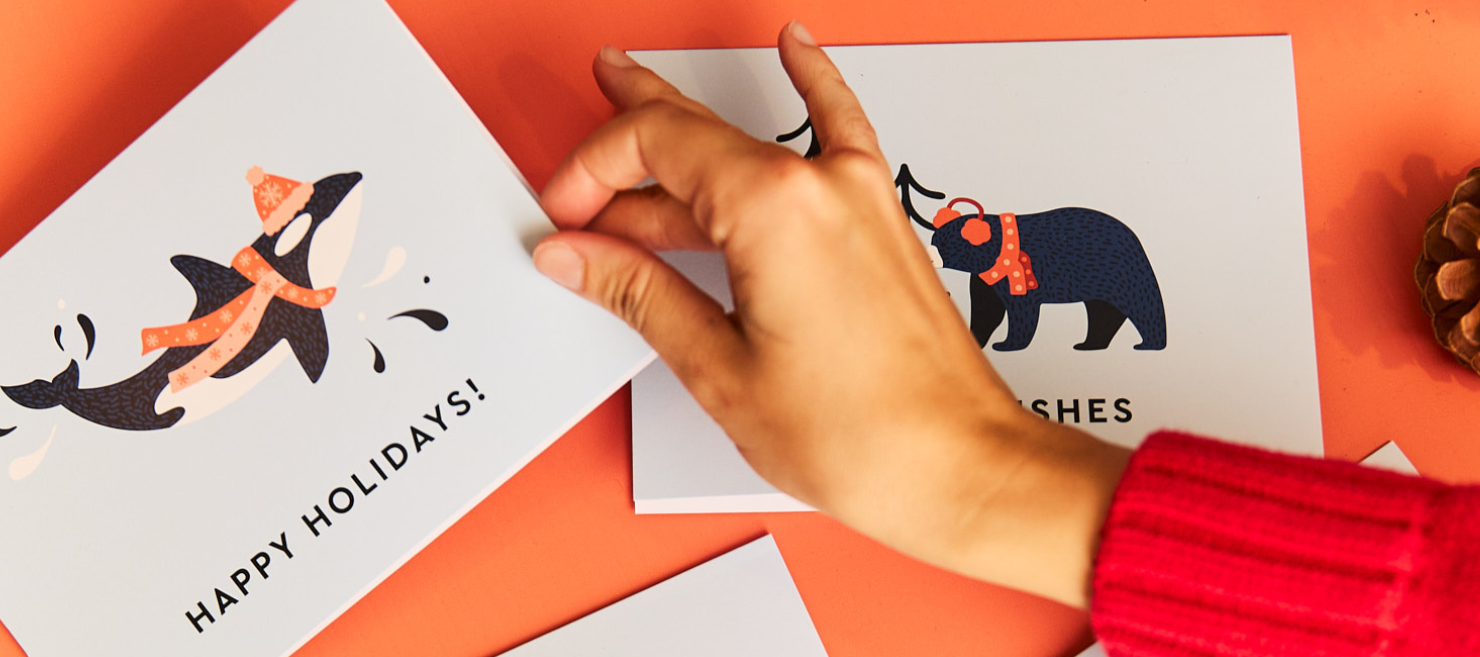 Hand holding a card with holiday themed BC wildlife