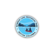 A circular enamel pin featuring a scenic illustration of Bowron Lake Provincial Park in British Columbia, with two people rowing a red canoe on blue water, surrounded by a light blue border with black text.