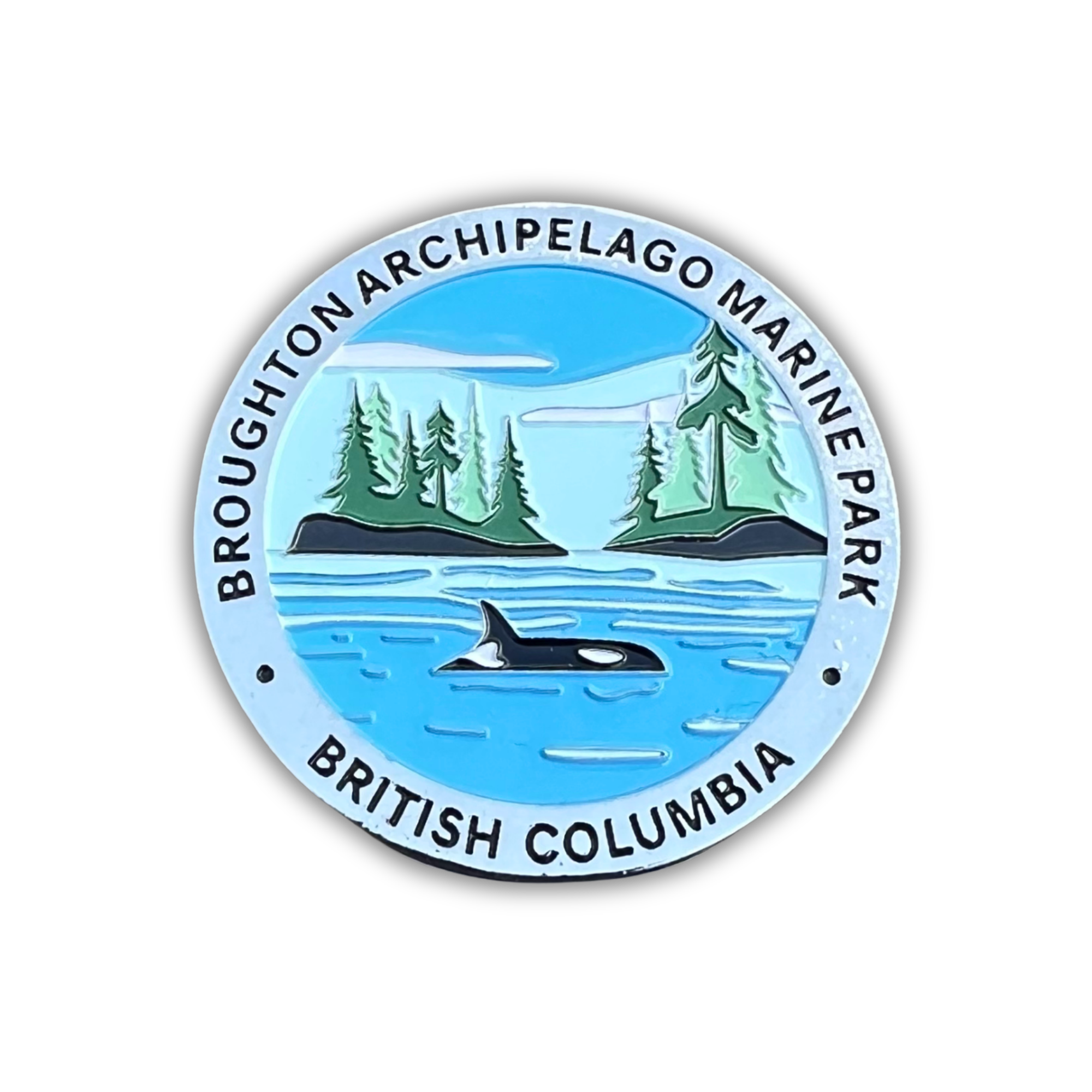 A circular enamel Magnet featuring a scenic illustration of Broughton Archipelago Marine Park in British Columbia, with an orca in blue water, green pine trees, and black text on a white background.