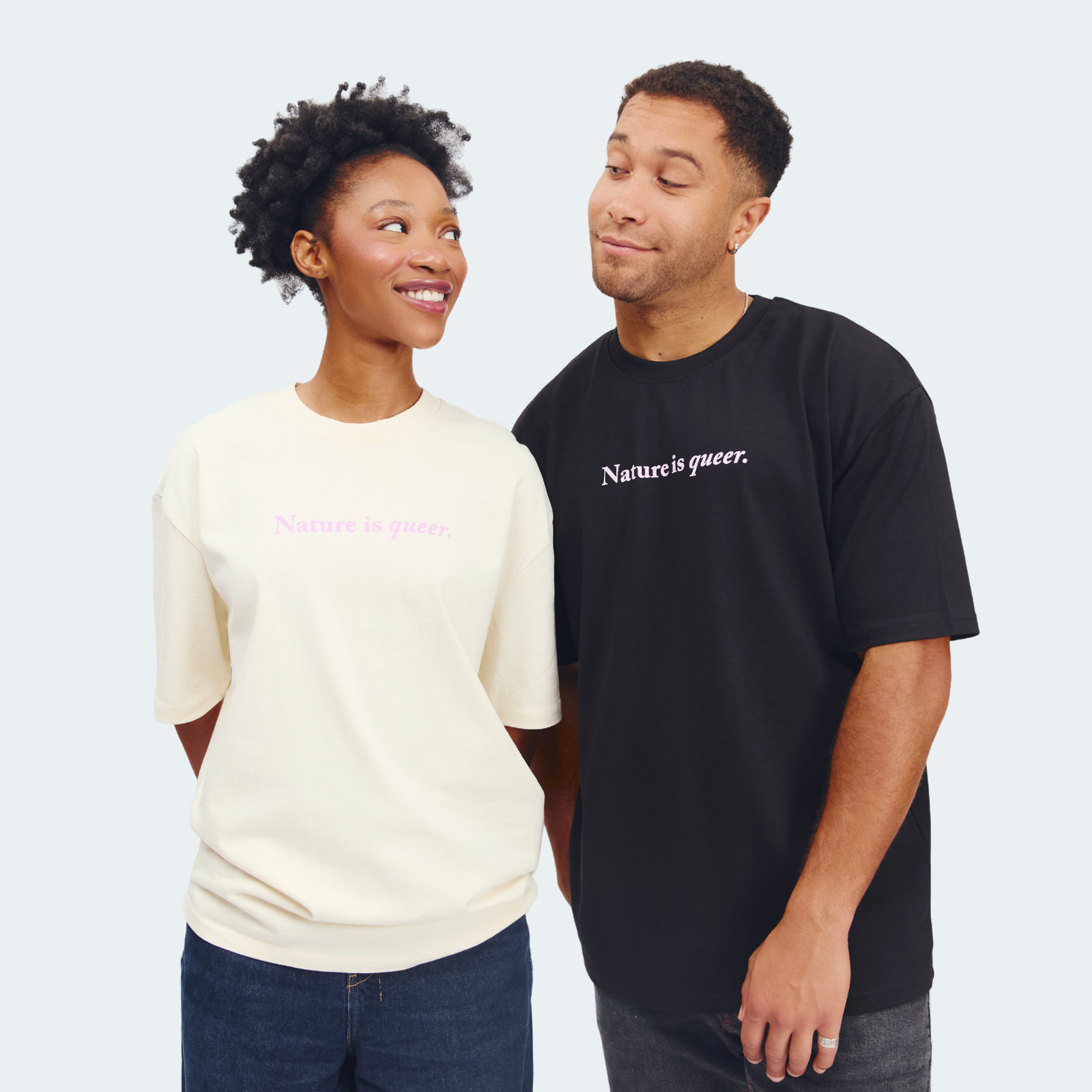Two models wearing matching graphic t-shirts with the text 'Nature is queer.' printed on the chest.