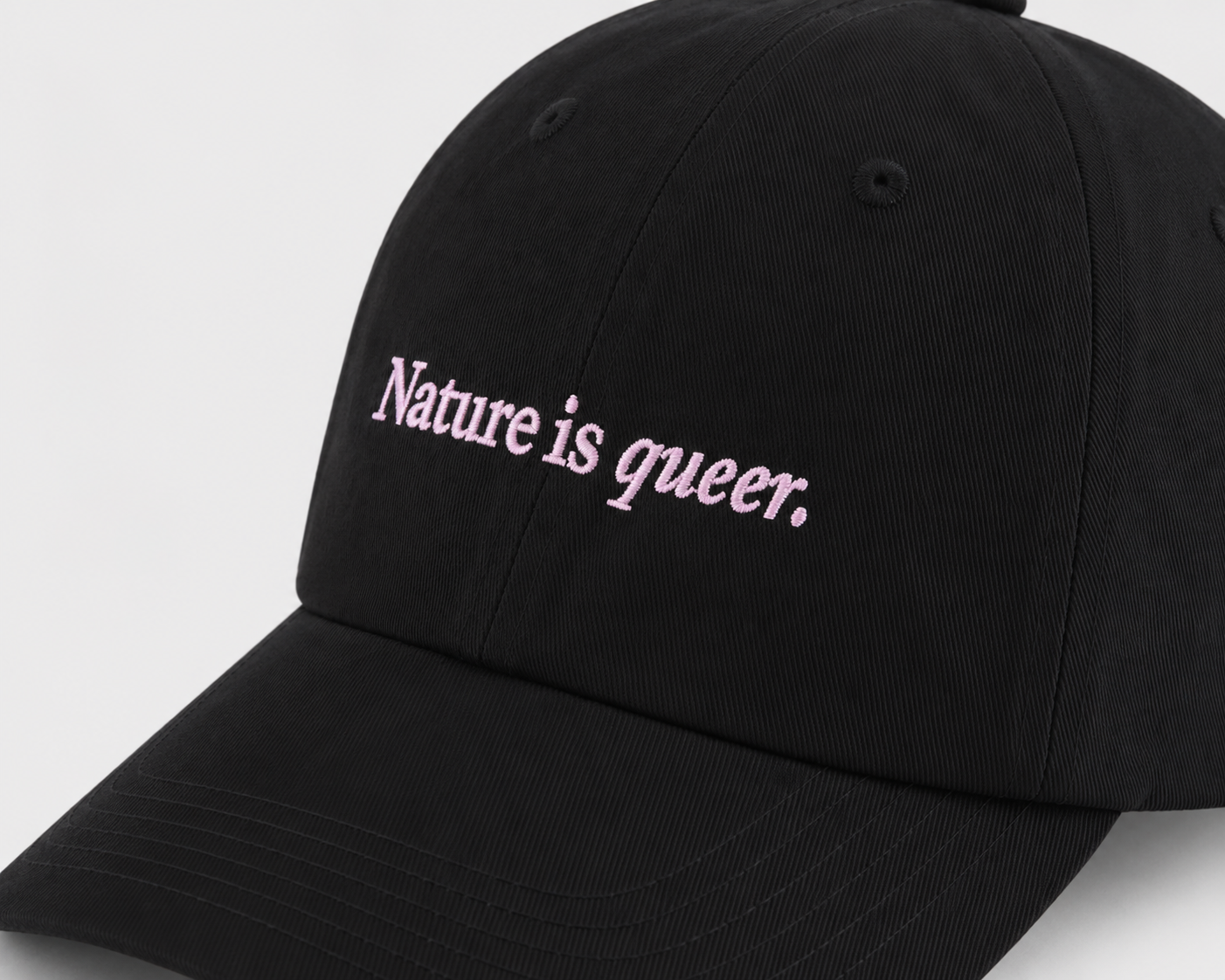 A black baseball cap with the phrase 'Nature is queer.' embroidered in pink script across the front panels, shown against a light gray background.