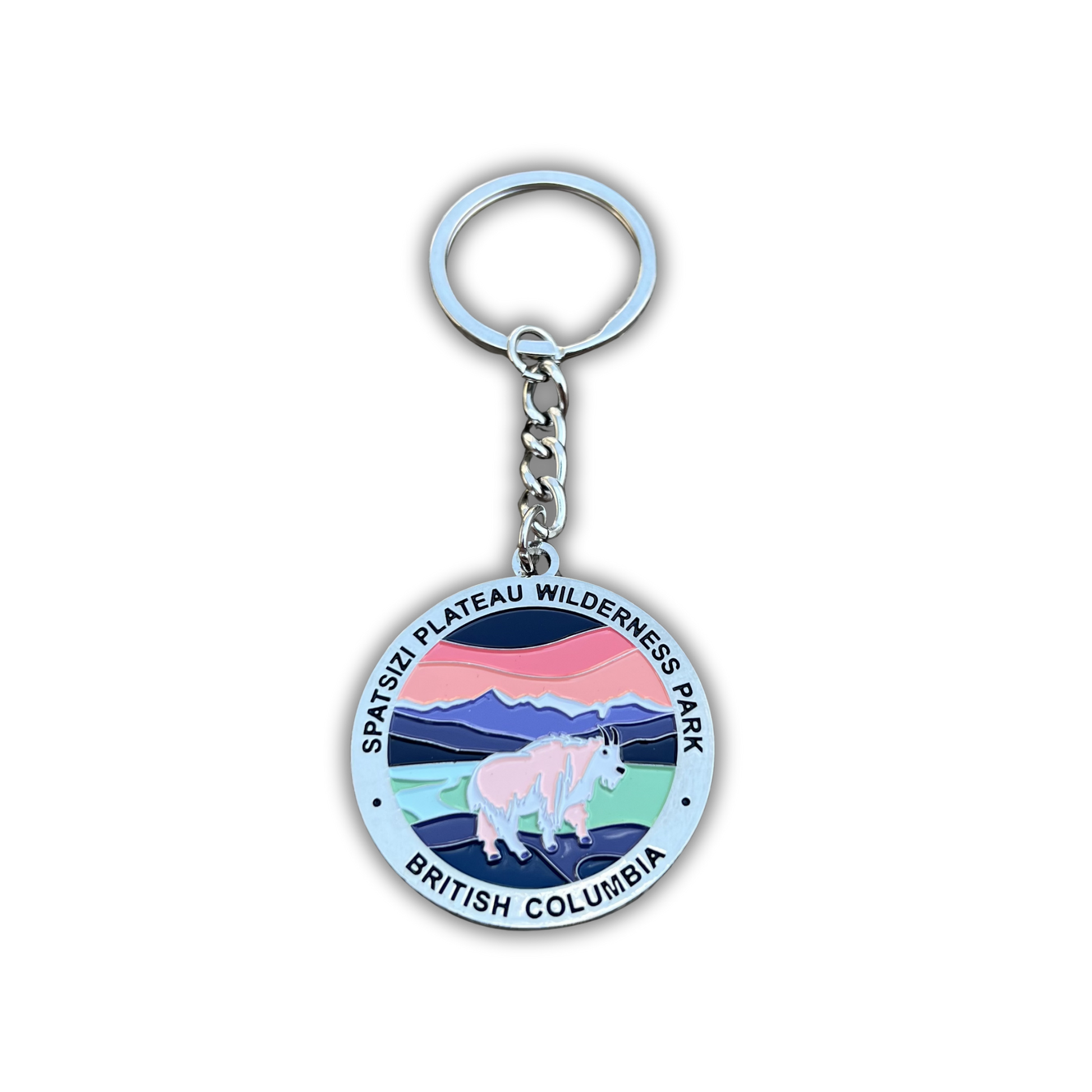 A round metal keychain featuring a colorful emblem of Spatsizi Plateau Wilderness Park in British Columbia, with a white rhinoceros and mountains, attached to a silver split ring and chain.