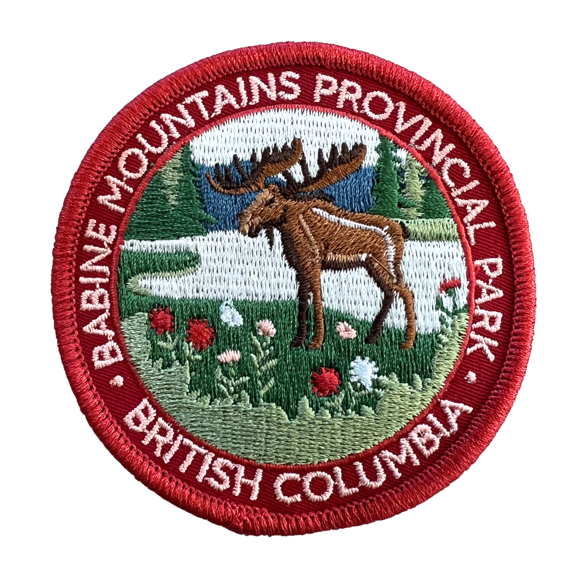 An embroidered circular patch for Babine Mountains Provincial Park, British Columbia, featuring a brown moose in a snowy landscape with red flowers and a red border.